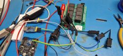 Electronic Setup for TuyaMCU Configuration Electronic setup with multiple cables, wires, and modules on a blue workbench.