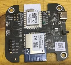 PCB with ZS3L and WBRG1 modules, a USB‑C port, and labeled pins on a wooden surface