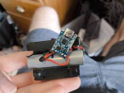 Electronic Circuit with Battery Person holding a small electronic board with wires and a battery.
