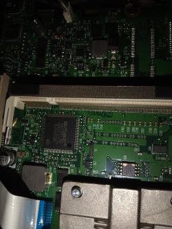 Zdjęcie płyty głównej laptopa HP Compaq 6735b, skupiające się na różnych układach scalonych.