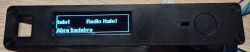 Front panel of the enclosure with an LCD display showing the text Radio Italo! and Abra kadabra.