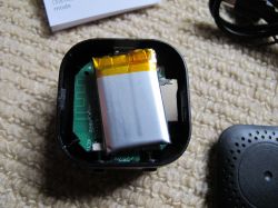 Opened Electronic Device with Battery The interior of a small electronic device with a visible lithium-polymer battery and circuit board.