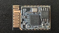 Close-up of an electronic module with a printed antenna and ICs on a black PCB