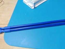 Close-up of blue electrical wires on a light blue surface.