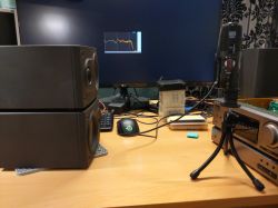 Biurko z zestawem audio, mikrofonem i monitorem z wykresem.