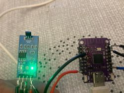 Hall sensor module A3144E and microcontroller board connected with wires.