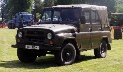 Militarny UAZ z brezentowym dachem i brytyjską tablicą rejestracyjną na trawie