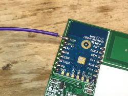 Soldered Wire on WiFi Module WiFi module with soldered wire on a workbench.