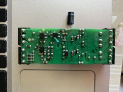 Płytka PCB z uszkodzonym kondensatorem leżącym obok na laptopie