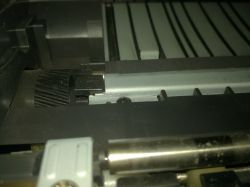 Wnętrze drukarki z widocznymi elementami mechanicznymi.