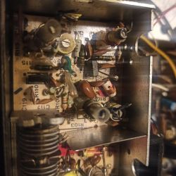 Wnętrze urządzenia elektronicznego z widocznymi komponentami na płytce obwodu drukowanego.