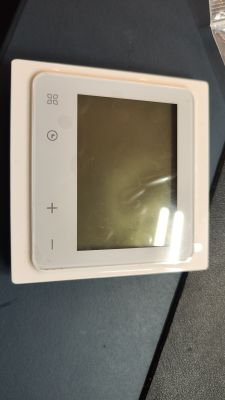 White electronic thermostat with large LCD screen and touch buttons