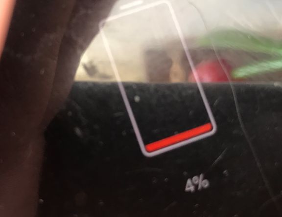 Ekran smartfona z ikoną baterii na czerwono i poziomem naładowania 4%