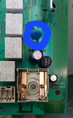 Zbliżenie na płytkę elektroniczną z niebieskim elementem zaznaczonym na niebiesko.