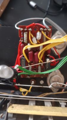 Płytka elektroniki z rezystorami, kondensatorami i wiązką kolorowych przewodów w obudowie urządzenia