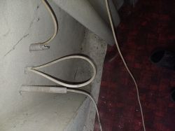 Zbliżenie na trzy kable wychodzące ze ściany.