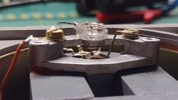 Zdjęcie wnętrza urządzenia diagnostycznego SUS-9 z widocznym precyzyjnym ustrojem magnetoelektrycznym.