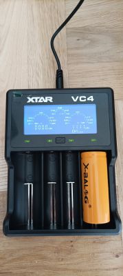 Ładowarka XTAR VC4 z akumulatorem X-BAL 18650 i wyświetlaczem pokazującym różne parametry.