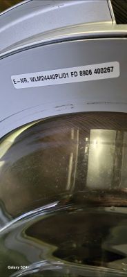 Zbliżenie na drzwi pralki Bosch z widoczną etykietą modelu WLM24440PL/01