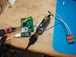 Electronic setup on a wooden desk with connected USB-TTL devices on a test board.