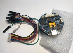 Moduł ESP32-S3-Touch-LCD-1.28 w kształcie koła z dołączonym zestawem kolorowych przewodów połączeniowych.