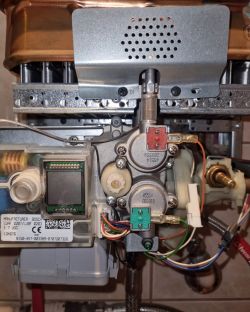 Wnętrze piecyka gazowego Junkers WRDP 11-2 B23 z widocznymi elementami elektrycznymi i hydraulicznymi.