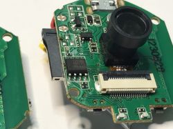 Camera module with lens, circuit board, and connectors shown in close-up.