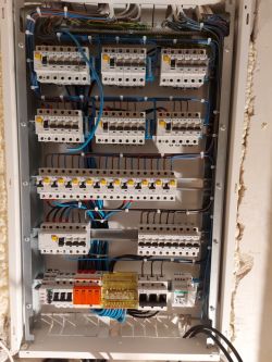 Zdjęcie profesjonalnie zamontowanej skrzynki elektrycznej z włącznikami i kablami.
