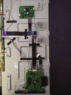 Wnętrze telewizora z widocznymi płytkami PCB i taśmami połączeniowymi