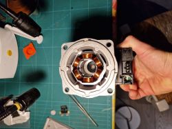 Top view of an electric motor with visible copper windings and electrical connector