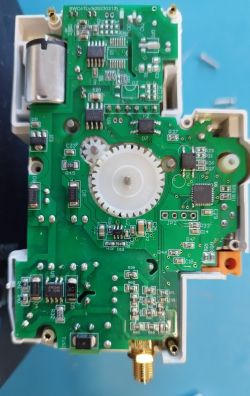 View of the inside of an electronic circuit breaker with a visible PCB, motor, and gear mechanism.