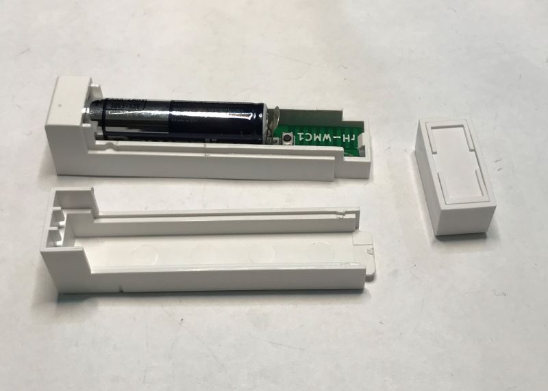 Disassembled plastic sensor with a battery and electronic circuit board.