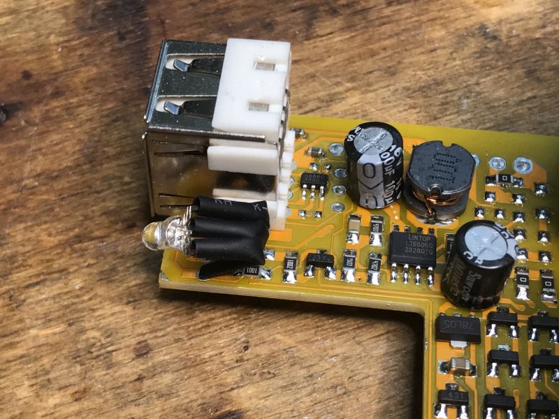 Wnętrze przetwornicy samochodowej z widocznym portem USB i elementami elektronicznymi.