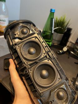 JBL Xtreme 3 bez obudowy trzymany w ręku, ukazujący wnętrze i głośniki.