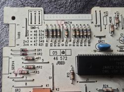 Zbliżenie na płytkę drukowaną z widocznymi elementami elektronicznymi i oznaczeniami.