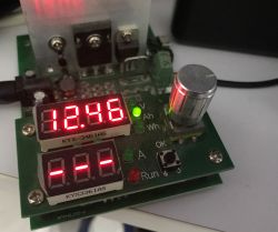 Measurement module on a PCB with red LED display reading 12.46 and a metal knob