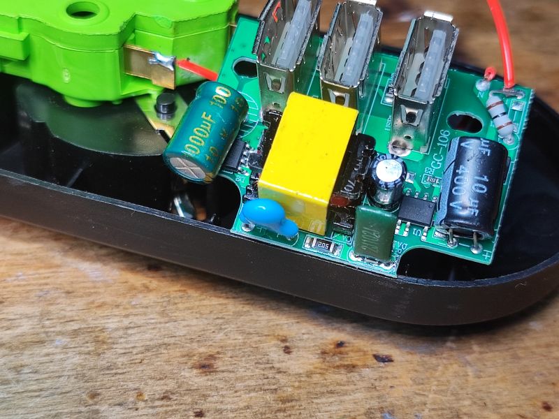 Wnętrze rozebranej listwy antyprzepięciowej z elektronicznymi komponentami.