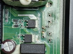 Damaged PCB section labeled “HI VOLT FET” Close-up of damaged green PCB with electronic components and missing elements
