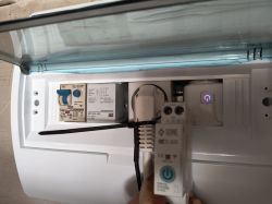 Widok wnętrza rozdzielnicy z modułami elektrycznymi i wyjętym przekaźnikiem WiFi.