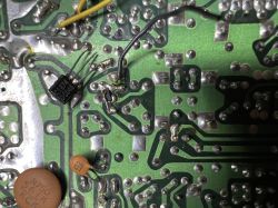 Spód płytki PCB z lutami, przewodami i elementami; widać układ C614 DC006 oraz kondensatory.