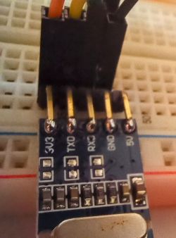 Close-up of a USB-UART converter connected to a breadboard.