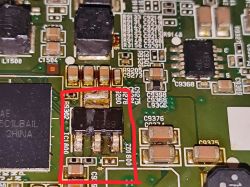 Close-up of a PCB with SMD parts; a black IC with three pins is highlighted in red
