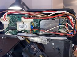 Wnętrze ekspresu do kawy De'Longhi ECAM 21.117.SB z widocznymi przewodami i komponentami elektronicznymi.