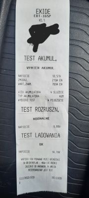 Wydruk z testera akumulatorów z wynikiem Wymień akumul., sugerującym konieczność wymiany baterii samochodowej.