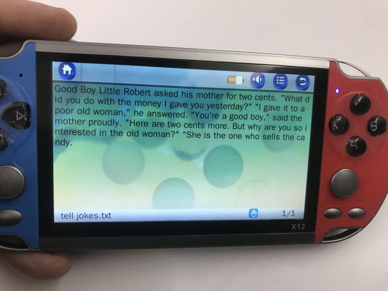 X12 handheld console in blue and red; screen shows an English text file reader