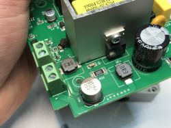 Close-up of a printed circuit board with electronic components such as capacitors, inductors, and screw terminals.