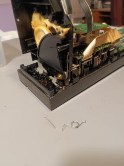 Widoczny mechanizm magnetofonu Technics z odłączoną sprężyną leżącą na stole