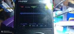 Ekran przenośnego oscyloskopu FNIRSI z niebieskim przebiegiem sygnału i napisem „RUN”.