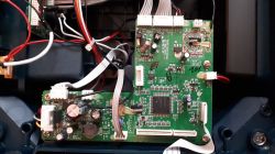 Płytka drukowana z zaznaczonym układem scalonym pod kwarcem, widocznymi przewodami i elementami elektronicznymi.