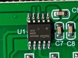 Close-up of a Hellosi H8G3006 chip on a green PCB, with visible U1 marking and nearby SMD capacitors.